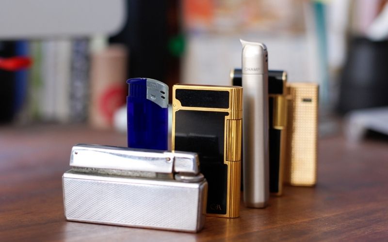 Photo of different types of lighter on wooden table top
