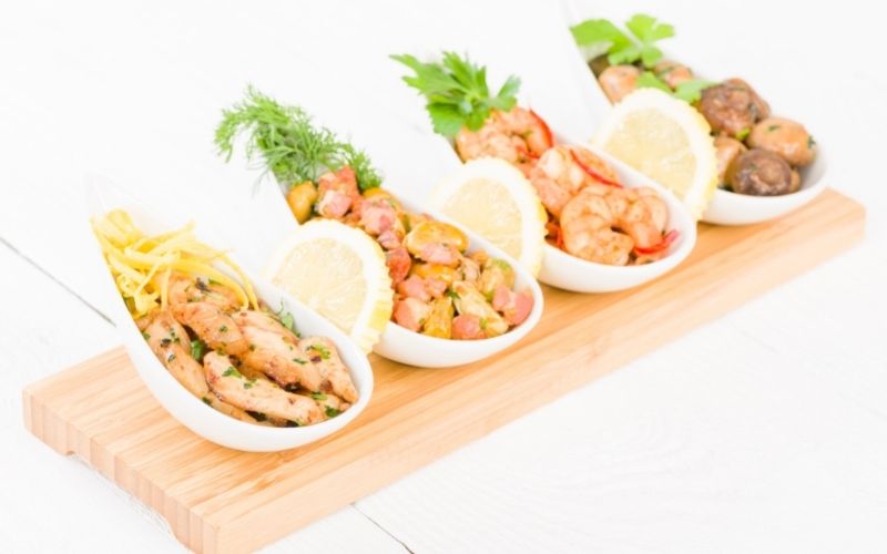 Photo of foods in 4 small plates placed over a wooden board