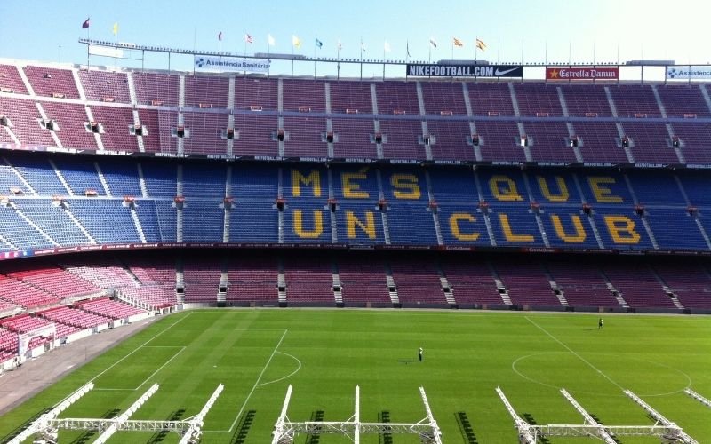 camp nou stands and seats in blue and red with the words Mes Que Un Club