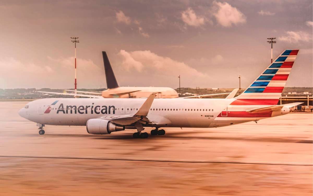 A photo of an American Airlines passenger plane in an airport beside another airplane.