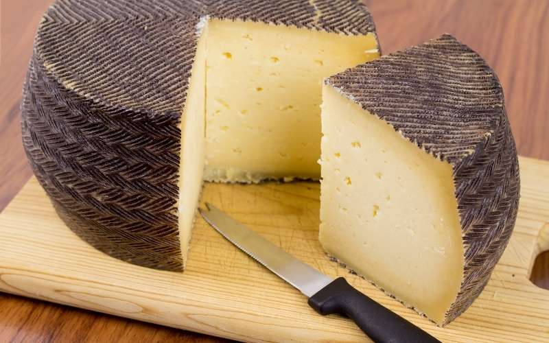 spanish manchego cheese portion with a special cutting knife