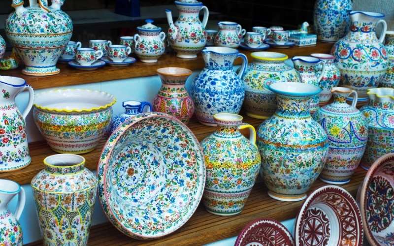 varied group of ceramic abjects in a spanish pattern on display shelves