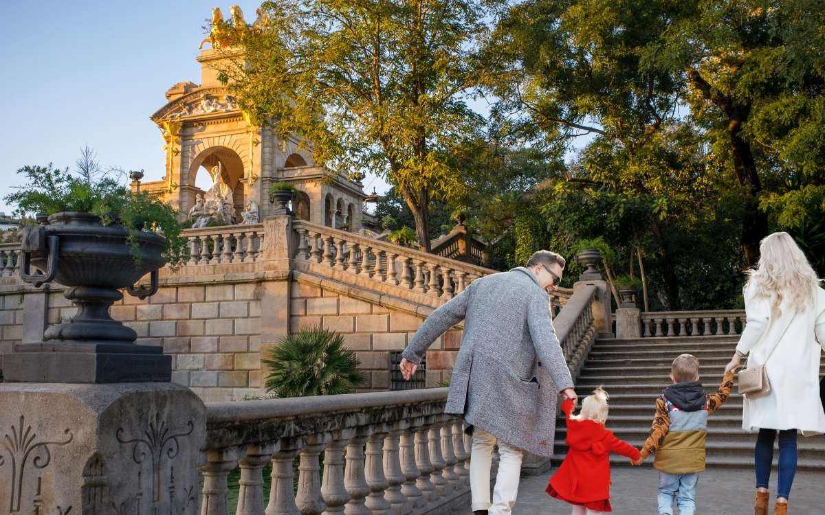 Photo of 2 adults and 2 kids walking in park