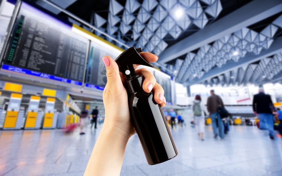 Photo showing a hand holding a black spray bottle