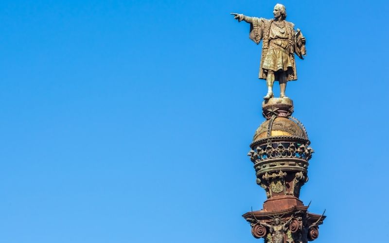 Photo of a statue standing on a high pole with blue background