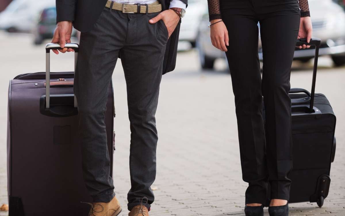 Phot of two person walking with their luggage