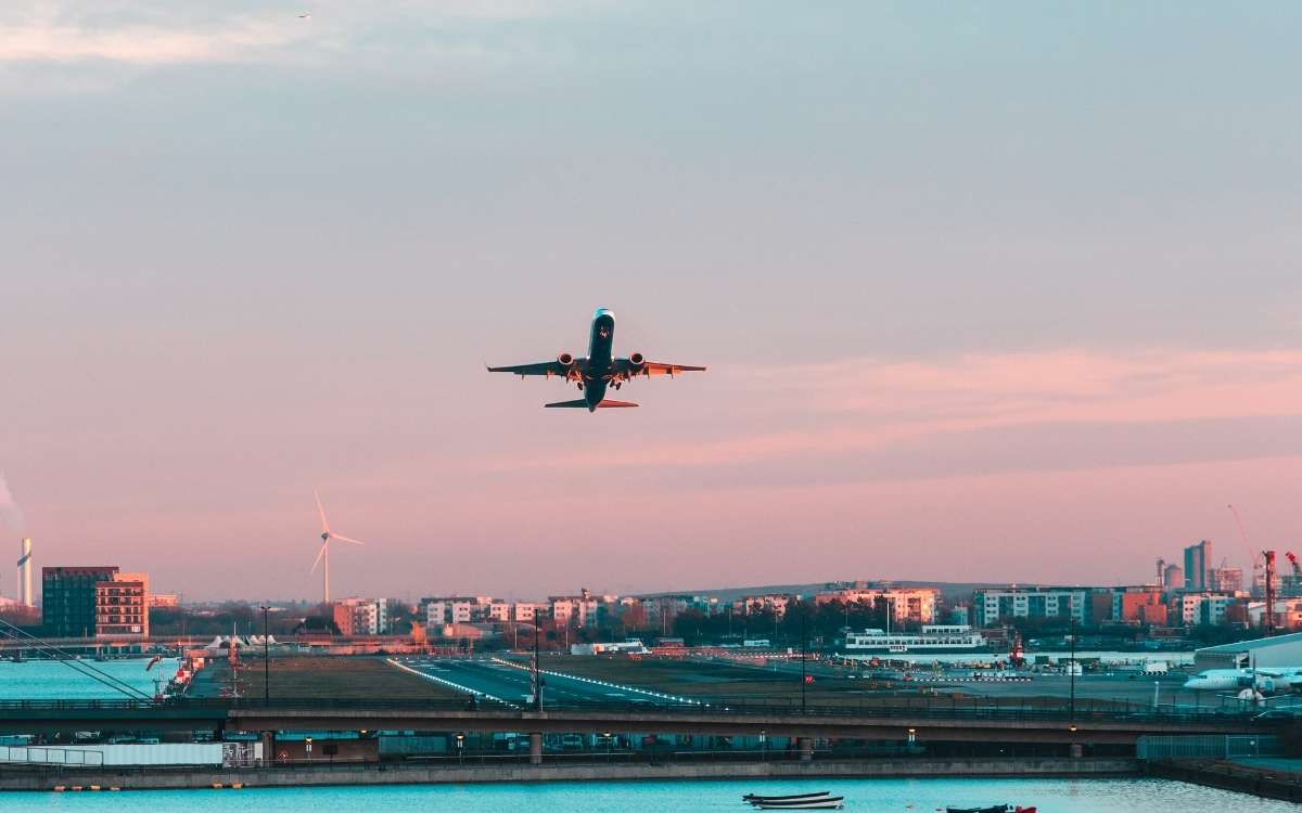 An airplane flying above the city at dawn