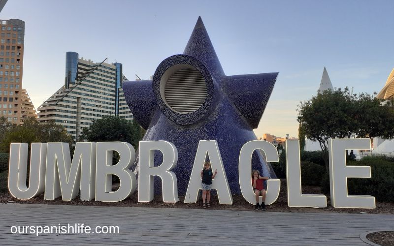 Two children sitting inside the letters of the UMBRACLE