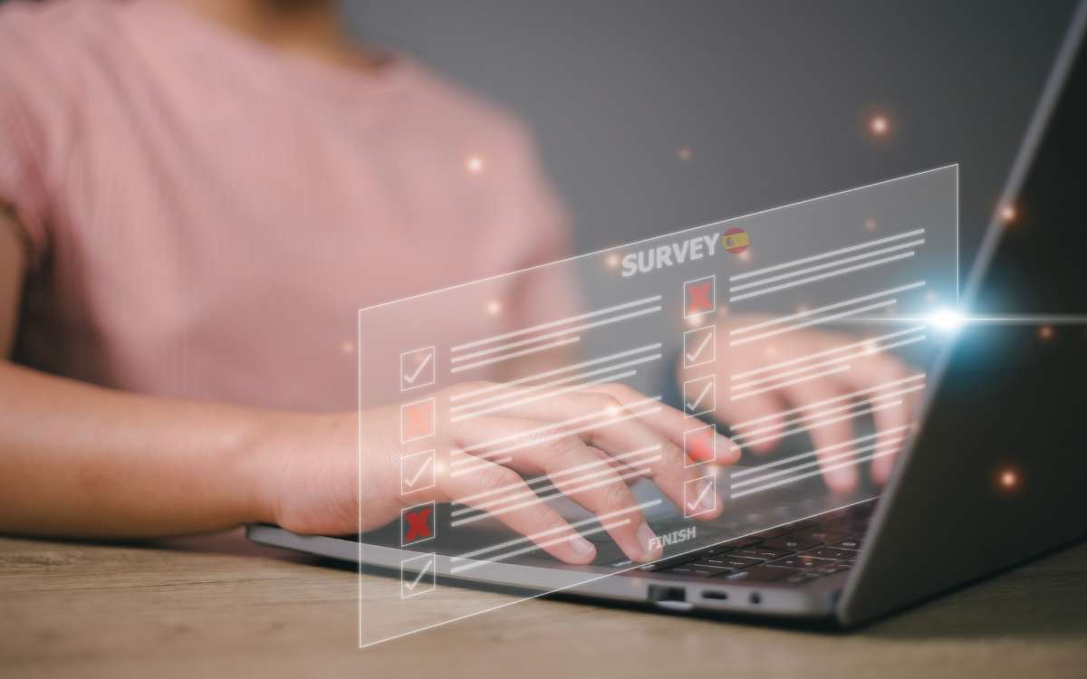 A person typing on a laptop about Paid Survey Sites Spain